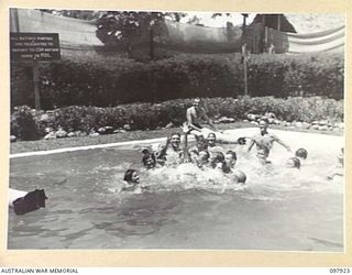 LAE, NEW GUINEA. 1945-10-20. AUSTRALIAN WOMEN'S ARMY SERVICE AND TROOPS OF FIRST ARMY PLAYING A GAME OF WATER POLO IN THE AUSTRALIAN NEW GUINEA ADMINISTRATIVE UNIT SWIMMING POOL. THE POOL IS THE ..