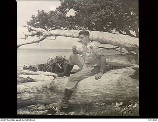 MOMOTE, LOS NEGROS ISLAND, ADMIRALTY ISLANDS. C. 1944-04. AFTER LUNCH SQUADRON LEADER IAN LOUDON, COMMANDING OFFICER OF NO. 76 (KITTYHAWK) SQUADRON RAAF, RELAXES NEAR THE CALM PACIFIC OCEAN. HE ..