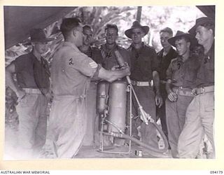 BOIKEN, NEW GUINEA. 1945-07-15. SERGEANT L.T. LEES, 2/6 CAVALRY (COMMANDO) REGIMENT (2), INSTRUCTING TROOPS IN THE USE OF A FLAME-THROWER