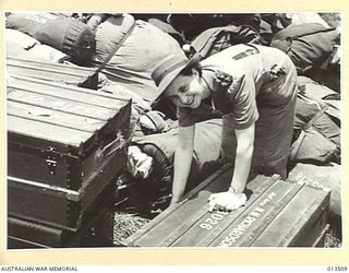 1942-11-11. AUSTRALIAN NURSES RETURN TO NEW GUINEA. SISTER N. RICHARDSON OF VICTORIA SORTS OUT HER BAGGAGE. (NEGATIVE BY G. SILK)