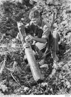 WIRUI MISSION, WEWAK AREA, NEW GUINEA, 1945-05-15. PRIVATE CRANIS, 2/4 INFANTRY BATTALION CHECKING OVER WHAT WAS A WELL SITED JAPANESE TYPE 92 WOODPECKER MACHINE-GUN. THE MISSION AND AREA WAS VERY ..