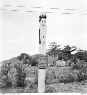 SALAMAUA, NEW GUINEA. 1945-04-24. A NATIVE TOTEM POLE IN USE AS A SIGN POST