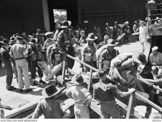 CAIRNS, QLD. 1944-10-30. HEAVILY LADEN TROOPS OF THE 2/4 INFANTRY BATTALION MOVING ABOARD THE TROOPSHIP USS MEXICO DURING THE MOVEMENT TO NEW GUINEA OF ELEMENTS OF 6 DIVISION