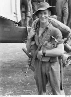 NADZAB, NEW GUINEA. 1943-09-20. WX3006 SERGEANT G. B. J. MURPHY MM, 2/16TH BATTALION, 21ST AUSTRALIAN INFANTRY BRIGADE, PAUSES BEFORE ENTERING THE AIRCRAFT