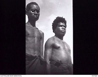 SALAMUA, NEW GUINEA. 1943-09-20. TWO NATIVE LABOURERS. THE ONE ON THE LEFT HAS BEEN IN JAPANESE HANDS AND THE ONE ON THE RIGHT HAS BEEN WORKING FOR THE AUSTRALIAN NEW GUINEA ADMINISTRATIVE UNIT. ..