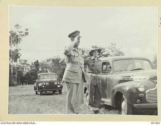 LAE AREA, NEW GUINEA. 1945-04-25. MAJOR-GENERAL C.H. SIMPSON, SIGNAL OFFICER- IN- CHIEF (1), RETURNING THE SALUTE ON ARRIVAL AT 19 LINES OF COMMUNICATION SIGNALS DURING HIS TOUR OF SIGNAL UNITS AND ..