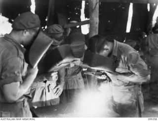 TOROKINA, BOUGAINVILLE, 1945-12-03. STUDENTS RECEIVING INSTRUCTIONS IN ARC-WELDING AT THE TOROKINA REHABILITATION TRAINING CENTRE