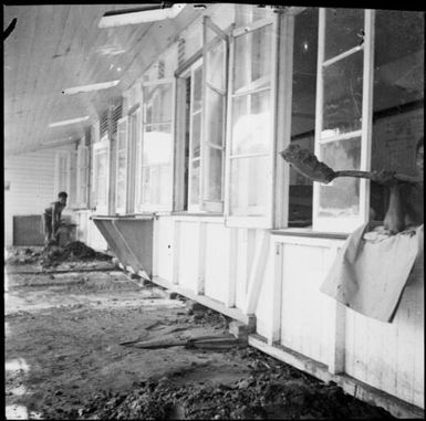 Volcanic debris being shovelled out of a building onto a verandah, Rabaul, New Guinea, 1937 / Sarah Chinnery