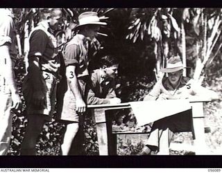 EDIE CREEK, NEW GUINEA. 1943-08-15. PERSONNEL OF HEADQUARTERS, ROYAL AUSTRALIAN ENGINEERS, 11TH AUSTRALIAN DIVISION, NEW GUINEA FORCE, LINE UP TO RECORD THEIR VOTES IN THE FEDERAL ELECTION. LEFT TO ..