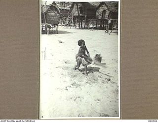 KAHIRU, PAPUA, 1943-12-02. A SMALL PAPUAN GIRL PLAYING CRICKET ON THE BEACH