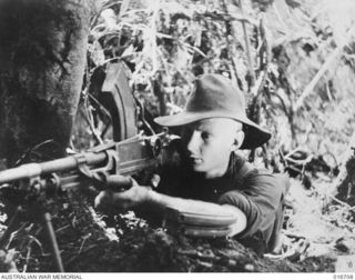 1944-03-22. NEW GUINEA. PTE. M.J. DRIVER (MAXIE) OF AN A.I.F. UNIT WHO ASSISTED IN MAKING THE DOCUMENTARY FILM "JUNGLE PATROL" PHOTOGRAPHED IN THE RAMU VALLEY AND FINISTERRE RANGE