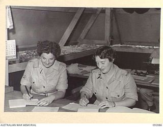 LAE, NEW GUINEA, 1945-05-21. CORPORAL E.C. NELSON, AMENITIES OFFICER (1), AND SERGEANT A.J. HOCKING (2), CHECKING OVER ARRANGEMENTS FOR SPORTING FIXTURES AND OUTINGS FOR AUSTRALIAN WOMEN'S ARMY ..