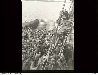 MOMOTE, LOS NEGROS ISLAND, ADMIRALTY ISLANDS. 1944-03-18. RAAF REINFORCEMENTS, TOGETHER WITH AMERICAN TROOPS, WAITING TO GO ASHORE FROM A LANDING CRAFT TANK