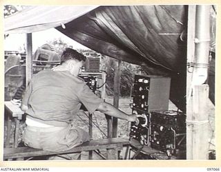 RABAUL, NEW BRITAIN. 1945-09-23. SERGEANT G.W. ASHLEY, 11 DIVISION SIGNALS OPERATING A 112 MEDIUM RANGE WIRELESS SET USED FOR COMMUNICATING FROM RABAUL TO LAE