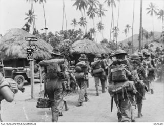 KAIAPIT, NEW GUINEA, 1943-09-27. TROOPS OF C COMPANY, THE 2/31ST AUSTRALIAN INFANTRY BATTALION, 25TH AUSTRALIAN INFANTRY BRIGADE, PASSING THROUGH KAIAPIT VILLAGE, SHOWING MARAWASA SIGN POST