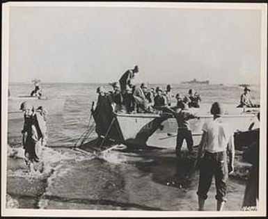 Troops of Americal Division land on beach of Guadalcanal without enemy opposition