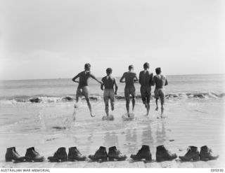 BORAM BEACH, WEWAK AREA, NEW GUINEA. 1945-08-30. SIGNALMEN OF HEADQUARTERS 8 INFANTRY BRIGADE DASHING INTO THE SURF