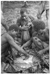 Men eating gwasu taro and coconut pudding