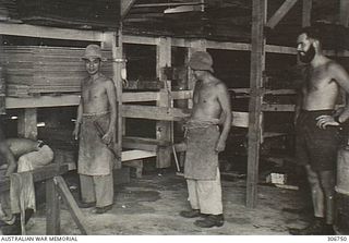 Manus Island. c.1948. Members of the Japanese War Criminals Saw Mill Party sorting and stacking timber for the construction of the new store house being built at the RAN War Criminal Compound at ..