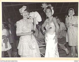 LAE, NEW GUINEA. 1945-11-08. LANCE CORPORAL MOODY (1) AND CORPORAL A. MILGATE (2) WHO WERE FIRST AND SECOND PRIZE WINNERS IN THE BEST COSTUME SECTION AT THE FANCY DRESS PARTY HELD BY MEMBERS OF ..