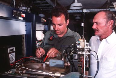 STAFF SGT. Stanton Yarbrough, a maintenance technician with the1957th Information Systems Group (ISG), adjusts a radiometer as Eugene Kraus looks on at the Palehua Solar Observatory. The 1957th ISG also maintains radio communication between commanders, air bases and military forces throughout the Pacific area, and is responsible for data automation, telephone systems, power production, the Military Affiliated Radio System and various other responsibilities