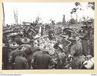 BORAM BEACH, NEW GUINEA. 1945-10-13. THE FIRST BATCH OF TROOPS TO LEAVE THE WEWAK AREA UNDER THE PRIORITY DEMOBILISATION SCHEME WERE MEMBERS OF 6 DIVISION. SHOWN, THE EMBARKATION OFFICER CHECKING ..