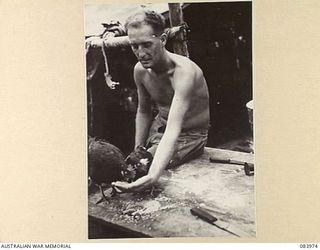 BOUGAINVILLE, SOLOMON ISLANDS. 1944-12-10. PRIVATE E.R. BROCK, D TROOP, 5 BATTERY, 2 FIELD REGIMENT, ROYAL AUSTRALIAN ARMY, FEEDS HIS TWO BLACK ORPINGTON HENS. HE HAS KEPT THE HENS AND MAINTAINED ..