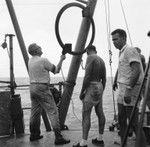 John D. Isaacs (left), unidentified man (center), and Willard Bascom (right) feed wire out, Bikini Atoll area