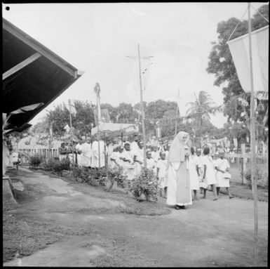 Nun leading a group of children and priests, in the Corpus Christi Procession, Vunapope Sacred Heart Mission, Kokopo, New Guinea, 1937, 2 / Sarah Chinnery