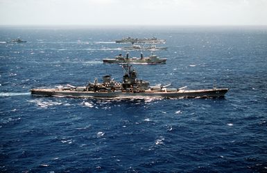 A starboard beam view of, from forefront: the battleship USS MISSOURI (BB-63), the Australian underway replenishment tanker HMAS SUCCESS (AOR-304), the Canadian operational support ship HMCS PROVIDER (AOR-508) and another tanker underway off the coast of Hawaii during Exercise RimPac '88