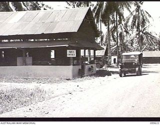 LAE, NEW GUINEA, 1946-01-09. THE AREA OFFICE, THE VISITORS CAR PARK AND THE UNIT COOL ROOM AT AUSTRALIAN ARMY CANTEENS SERVICE BULK STORES