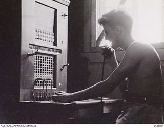 PORT MORESBY, NEW GUINEA. 1943-07-14. VX136380 SIGNALMAN I. CONNELL OPERATING THE TERMINAL SWITCHBOARD FOR THE PORT MORESBY - DOBODURA LINE