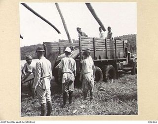 MUSCHU ISLAND, NEW GUINEA, 1945-09-08. JAPANESE SOLDIERS UNLOADING ENGLISH EQUIPMENT FROM TRUCKS. JAPANESE SOLDIERS ON THE ISLAND, UNDER THE CONTROL OF HQ 6 DIVISION, ARE CONSTRUCTING THEIR OWN ..