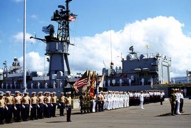 Honor guards from the various military services participate in the designation and departure ceremony for the Unknown Serviceman of the Vietnam Era. In the background, crew members man the rails of the USS BREWTON (FF 1086). The BREWTON will transport the Unknown Serviceman to Naval Air Station, Alameda, California
