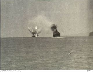 Pacific Area. 1944-12-14. A United States Navy destroyer, on the left, after being struck by a torpedo from a Japanese aircraft. The damaged ship is shown being sunk by gunfire from another United ..