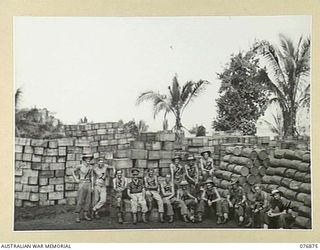 JACQUINOT BAY, NEW BRITAIN. 1944-11-11. PERSONNEL OF THE 14TH SUPPLY DEPOT PLATOON AMIDST LARGE STACK OF STORES AT ONE OF THE 6TH INFANTRY BRIGADE BRIDGEHEADS. IDENTIFIED PERSONNEL ARE: VX147858 ..