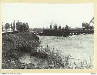 LAE, NEW GUINEA. 1944-08-09. TROOPS OF THE 20TH FIELD COMPANY, SURVEYING THE DAMAGE DONE TO THE BUTIBUM BRIDGE BY THE FLOODS WHICH WERE CAUSED BY THE VERY HEAVY RAINS IN THE CATCHMENT AREA