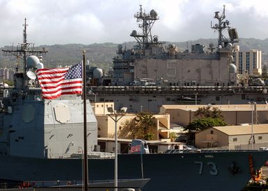 060807-N-4965F-002 (Aug. 7, 2006)US Navy (USN) Ticonderoga Class Guided Missile Cruiser (Aegis) USS PORT ROYAL (CG 73) (bottom) and the USN Tarawa Class Amphibious Assault Ship USS PELELIU (LHA 5) sit moored at Naval Station Pearl Harbor after completion of a six-month deployment in the Western Pacific and the USN 5th Fleet areas of operation. Nearly 6,000 Sailors and Marines assigned to Expeditionary Strike Group 3 (ESG-3) departed Pearl Harbor to operate in the Pacific and Indian Oceans. U.S. Navy photo by Mass Communication SPECIALIST 1ST Class James E. Foehl (Released)