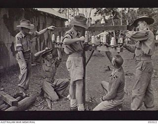 SOGERI VALLEY, NEW GUINEA, 1943-06-26. ELEMENTARY INSTRUCTION IN PERMANENT LINE CONSTRUCTION, USING BREAST HIGH POLES, AT THE NEW GUINEA FORCE SCHOOL OF SIGNALS. LEFT TO RIGHT: NX100538 LIEUTENANT ..