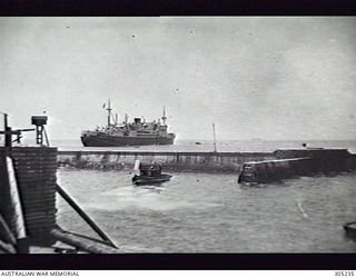 OCEAN ISLAND. 1940. THE ARMED MERCHANT CRUISER HMAS MANOORA AT HOME BAY. (NAVAL HISTORICAL COLLECTION)