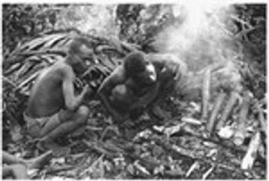 Sacrifice in shrine. Heating bamboos of blood pudding from sacrifice