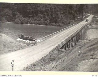 MAPE RIVER, NEW GUINEA, 1944-03-15. THE NO.1 TWO WAY PILE- BENT 340 FOOT BRIDGE OVER THE MAPE ROVER ON THE CULLINS ROAD, LINKING DREGER HARBOUR AND FINSCHHAFEN. THE ROAD IS NAMED AFTER THE LATE ..