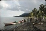 Several people approaching canoes