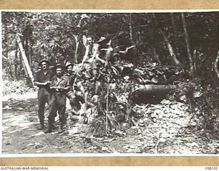 FINSCHHAFEN, NEW GUINEA, 1943-10-02. SIGNALLERS INSPECTING ONE OF THE MANY JAPANESE PILLBOXES ON THE OUTSKIRTS OF THE TOWN, AFTER ITS CAPTURE