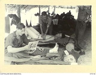 HANSA BAY-BOGIA, NEW GUINEA. 1944-08-09. MEDICAL OFFICERS OF THE ADVANCED DRESSING STATION, 2/15TH FIELD AMBULANCE TESTING A PATIENT FOR SCRUB TYPHUS. IDENTIFIED PERSONNEL ARE:- N456124 PRIVATE ..