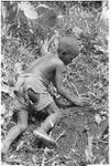 Boy planting taro in garden