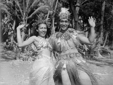 [Pacific Island man and woman in grass skirts]