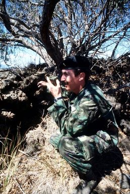 Forward air control team member First Lieutenant (1LT) Doug Bennett uses a hand radio to talk to an O-2 aircraft during search and rescue training conducted as part of exercise COPE ELITE '81. 1LT Bennett is from the 22nd Tactical Air Support Squadron