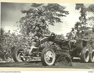 TOKO-BARARA ROAD, BOUGAINVILLE, SOLOMON ISLANDS. 1945-03-28. VX84631 SAPPER J. BURROWS, 15TH FIELD COMPANY, ROYAL AUSTRALIAN ENGINEERS, (1), OPERATING A PATROL GRADER ALONG THE ROAD IN THE SOUTH ..