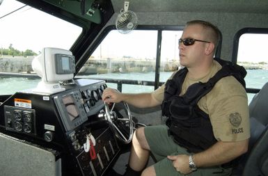 US Navy (USN) CHIEF MASTER-at-Arms (MAC) Jake M. Englander pilots a Naval Base (NB) Guam Security Force Harbor Patrol Police 28-foot Dauntless Sea-Ark high-speed patrol boat around NB Guam, Apra Harbor, Guam (GU), conducting harbor security patrols